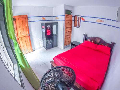 a bedroom with a red bed in a room at Palomino Hostel in Palomino