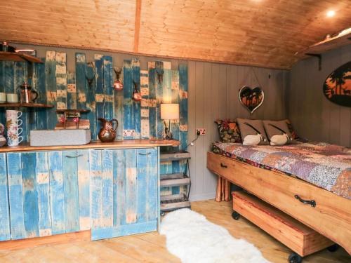 1 dormitorio con cama y techo de madera en The Hideaway, Shepherd's Hut, en Scarborough