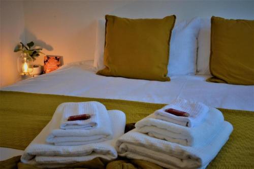 a bed with towels sitting on top of it at Peaceful, Lovely and Modern, Entire House in Edinburgh