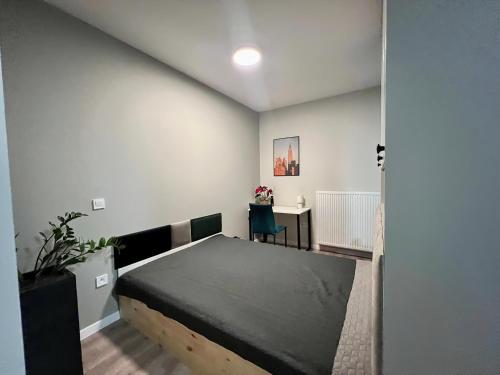 sypialnia z łóżkiem i biurkiem w obiekcie Apartamenty Milionowa z garażem i klimatyzacją w Łodzi
