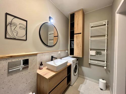 a bathroom with a sink and a washing machine at Milionowa 8 - Komfortowe Studio z Garażem i Klimatyzacją in Łódź