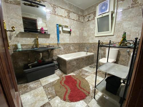 a bathroom with a tub and a sink and a toilet at Comfy private room with big sunny balcony near cairo airport مكان مودرن للاقامة دقائق من مطار القاهرة الدولى in Cairo