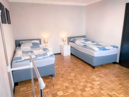 2 Einzelbetten in einem Zimmer mit 2 Lampen in der Unterkunft E10-Apartment in Neuhausen auf den Fildern