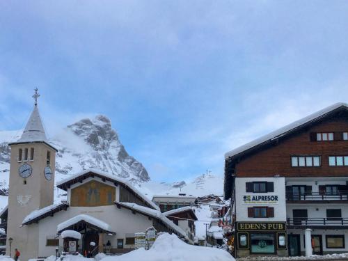 a building with a clock tower in front of a mountain at Studio Ancienne Bergerie Studio 3 by Interhome in Valtournenche