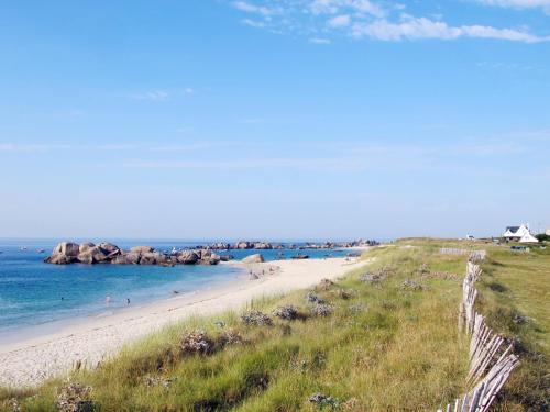 a beach with people in the water and rocks at Holiday Home Ty Louarn by Interhome in Kerlouan