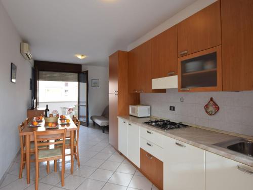 a kitchen with a table and a stove top oven at Apartment Acquamarina-4 by Interhome in Rosapineta