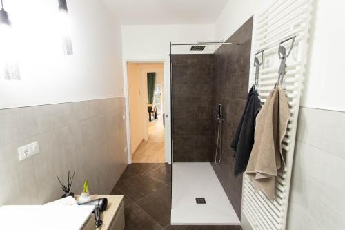 La salle de bains est pourvue d'une douche et d'un lavabo. dans l'établissement Moderno Appartamento 140 Bassano Centro, à Bassano del Grappa