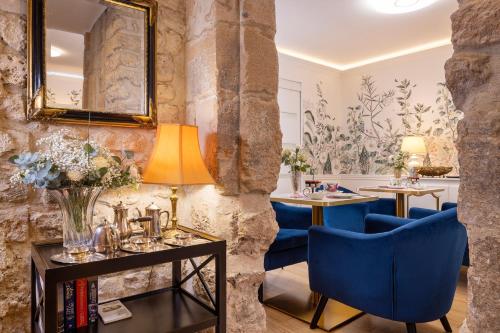 a living room with blue chairs and a mirror at Relais Hôtel du Vieux Paris in Paris
