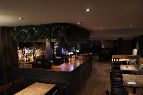 eine Bar in einem Restaurant mit Holztischen und -stühlen in der Unterkunft The George Hotel in Kirton in Lindsey