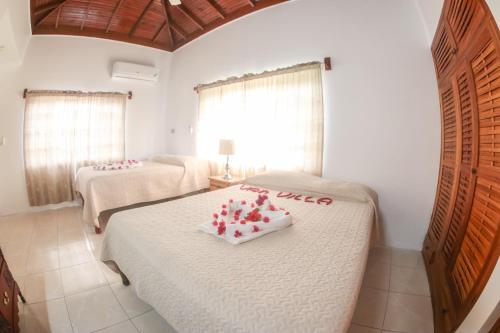um quarto com duas camas com corações vermelhos em Van Villa Guesthouse em Negril