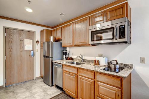 une cuisine avec des armoires en bois et un réfrigérateur en acier inoxydable dans l'établissement Slopeside 2741, à Keystone