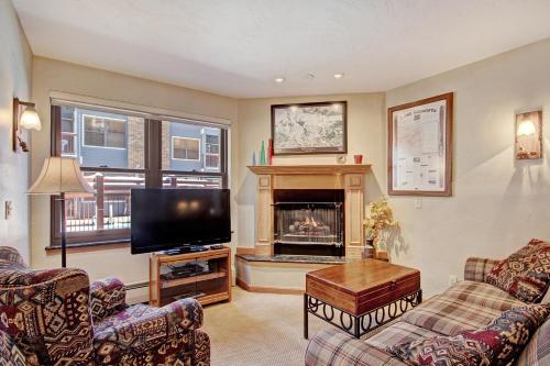 a living room with a tv and a fireplace at Standard Apartment in Breckenridge