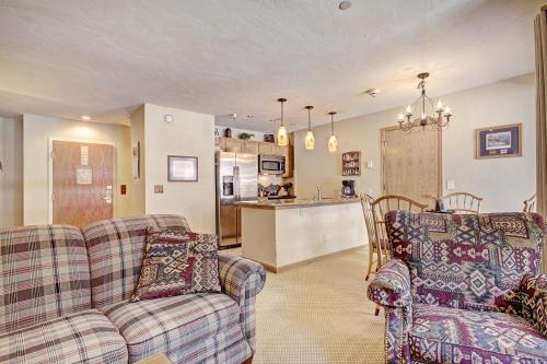 a living room with two couches and a kitchen at Standard Apartment in Breckenridge