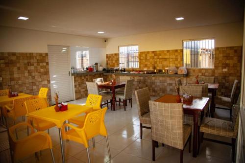 a restaurant with tables and chairs and a kitchen at Pousada O Sol De Maragogi in Maragogi