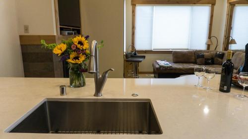 eine Küchentheke mit einer Spüle und einer Vase aus Blumen in der Unterkunft Ski Trails 4070 in Truckee