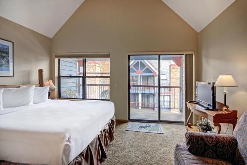 a hotel room with a large bed and a balcony at River Mnt Lodge W323 in Breckenridge