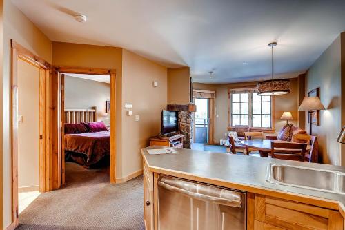 een keuken met een wastafel en een woonkamer bij Dakota Lodge 8513 in Keystone