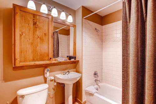 een badkamer met een toilet, een wastafel en een bad bij Dakota Lodge 8513 in Keystone