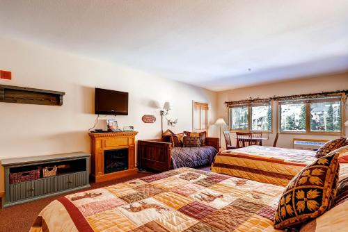 a hotel room with two beds and a fireplace at Gateway 5070 in Keystone