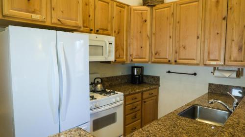 cocina con armarios de madera y nevera blanca en Ski Trails 4042, en Truckee