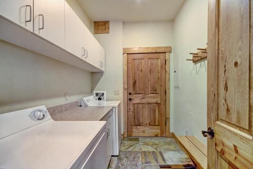 uma cozinha com armários brancos e uma porta de madeira em Mountain Thunder M803 em Breckenridge