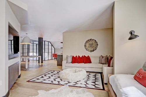 a living room with a white couch and red pillows at Iconic 5 Bedroom Penthouse at the Ritz-Carlton in Vail