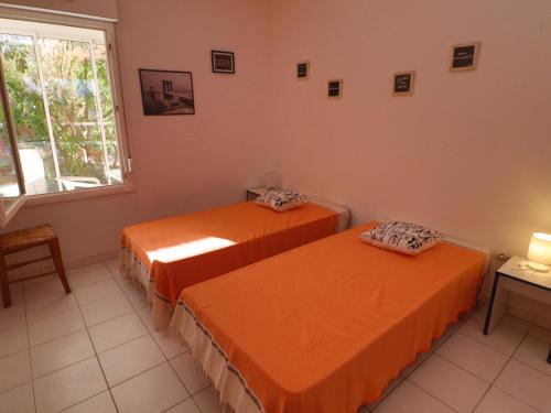 - 2 lits orange dans une chambre avec fenêtre dans l'établissement Appartement RDC à Sète: 3 pièces, Piscine, Accès Plage, Parking, Wifi - FR-1-472A-167, à Sète
