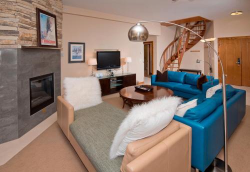 a living room with a blue couch and a fireplace at Osprey 303 in Beaver Creek