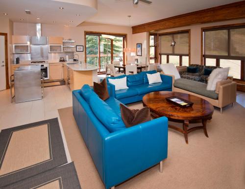 a large living room with blue couches and a table at Osprey 303 in Beaver Creek