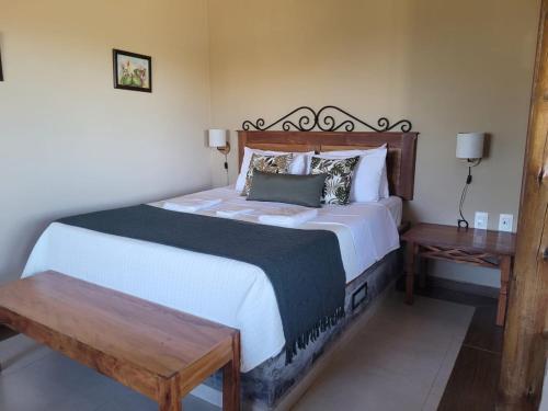 卡蘭卡斯的住宿－Pousada Gaya，一间卧室配有一张大床和两张桌子