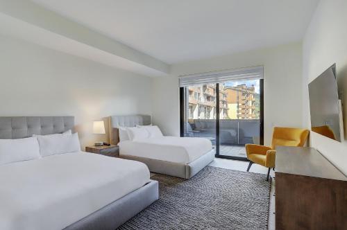 ベールにあるThe Lion Vail- 4 Br Modern Mountain Luxury- 2966 Sq Ft Condoのベッド2台とバルコニーが備わるホテルルームです。