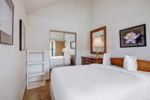 a bedroom with a large white bed and a mirror at River Mtn Lodge W219 in Breckenridge