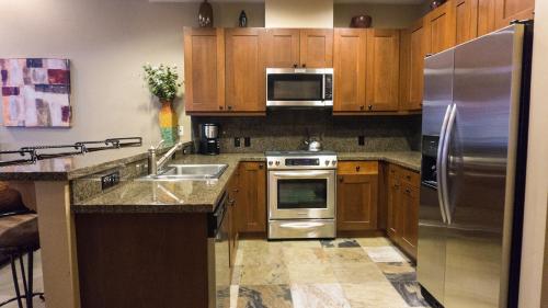 une cuisine avec des placards en bois et des appareils en acier inoxydable dans l'établissement Catamount 407C, à Truckee