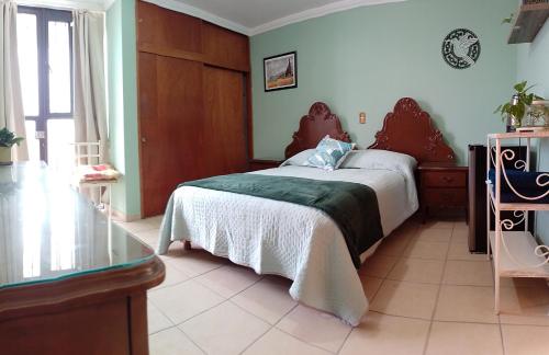 アグアスカリエンテスにあるHabitación independiente colibríのベッドルーム1室(ベッド1台、ガラス張りのテーブル付)
