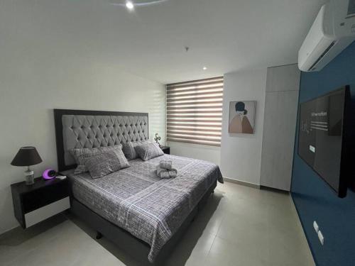a bedroom with a bed with a stuffed animal on it at New luxury apartment with king - size bed Ceibos in Guayaquil