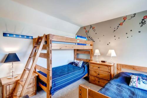 a bedroom with two bunk beds and a ladder at Plaza 1407 in Keystone