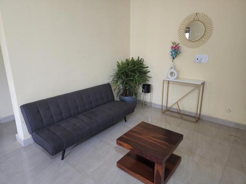 a living room with a black couch and a table at SD D'Souza Heritage Moira Flats with Reserved Parking in Moira