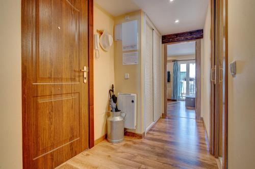a hallway with a wooden door and a trash can at Maravilloso apartamento en el corazón de Hondarribia in Hondarribia