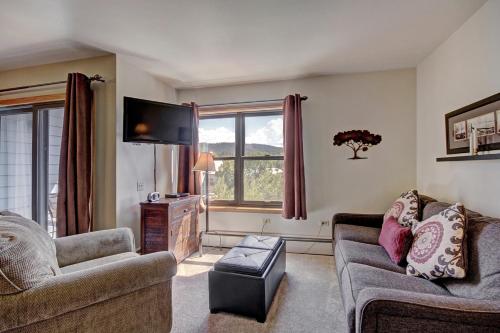 a living room with two couches and a flat screen tv at Studio Apartment with Balcony in Breckenridge