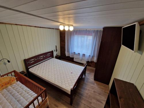 een slaapkamer met 2 bedden en een televisie. bij Ilūkstes Sauna apartamenti (bezkontakta) in Ilūkste