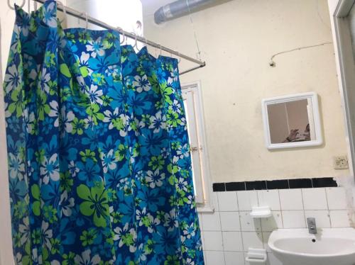 a bathroom with a shower curtain with a sink at Studio à centre ville boulevard pasteur in Tangier