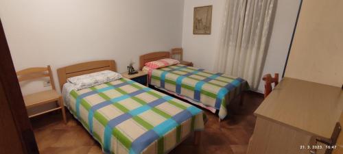 a small room with two beds in it at Apartmani Valentina in Veli Lošinj