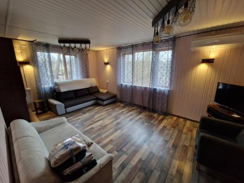 ein Wohnzimmer mit einem Sofa und einem TV in der Unterkunft Ilūkstes Sauna apartamenti (bezkontakta) in Ilūkste