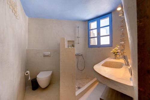 a bathroom with a sink and a toilet and a window at Charming Restored 300yr-0ld Guest House in Éxo Goniá