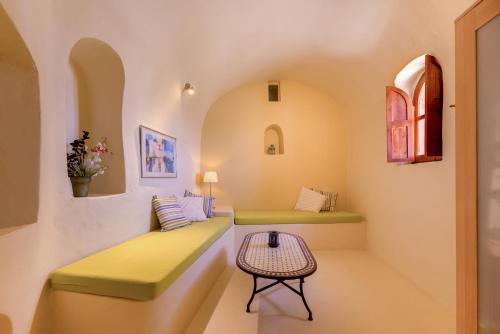 una habitación con 2 bancos verdes y una mesa en Charming Restored 300yr-0ld Guest House, en Éxo Goniá