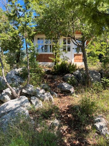 a house with trees and rocks in front of it at Baven -Toven Naturae in Rubik