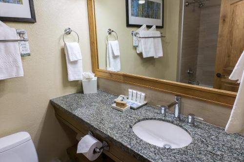 La salle de bains est pourvue d'un lavabo, d'un miroir et de toilettes. dans l'établissement Grand Summit G431, à Park City