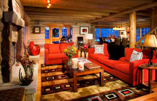a living room with red couches and a fireplace at Trappers Cabin in Beaver Creek