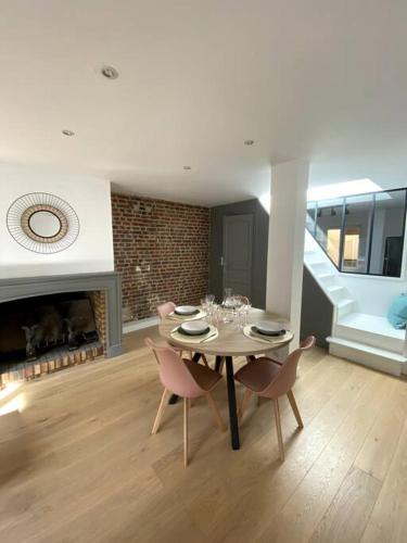 une salle à manger avec une table et des chaises et une cheminée dans l'établissement Appartement 50 m2 avec Rooftop Lille Centre, à Lille