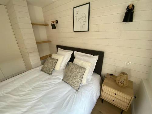 a bed with white sheets and pillows in a room at Appartement 50 m2 avec Rooftop Lille Centre in Lille